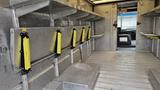 Interior of a 2006 Ford Econoline with metallic shelves and yellow supports mounted along the walls