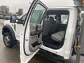 A white 2021 Ford F-550 with an open rear door revealing a spacious interior featuring gray seating and a center console