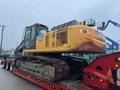 A yellow and black 2014 John Deere 350G excavator positioned on a flatbed trailer with tracks and a large cab