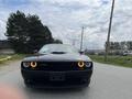 A black 2017 Dodge Challenger with distinctive round headlights and a muscular front grille is facing the viewer