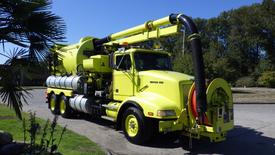 A bright yellow 1991 Western Star 3800 vacuum truck with a large hose attached at the front and multiple tanks on the side