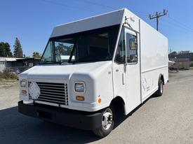 A white 2011 Ford Econoline van with a boxy design and large windshield featuring a front grille with horizontal slats and one round headlight on each side