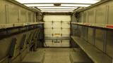 Interior of a 2011 Ford Econoline van with metal shelving on both sides and a large rear door