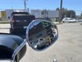 A close-up view of the mirror of a 2004 Harley-Davidson Flhtcui motorcycle reflecting vehicles behind it