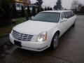 A white 2008 Cadillac limousine with a long body and elegant design featuring chrome wheels and a front grille with the Cadillac emblem