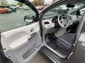 Interior view of a 2013 Toyota Sienna showing the driver's side with a gray door panel steering wheel and dashboard with controls and seating areas visible