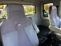 The image shows the interior of a 2013 International DuraStar 4300 truck with two front seats visible and a simple cab design