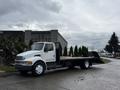 A white 2008 Sterling Acterra flatbed truck parked with its bed extended and empty