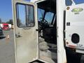 A 2010 Freightliner MT45 Garbage Truck with an open driver's door revealing the interior and driver's seat