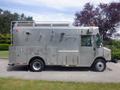 A 2007 Morgan Olson Workhorse W42 is a silver delivery truck featuring multiple side compartments and a roof rack with a light on top