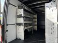 Interior view of a 2021 Mercedes-Benz Sprinter van featuring metal shelving units on both sides designed for storage and organization