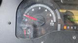 A close-up of a vehicle's dashboard showing the RPM gauge with a needle pointing near zero and other indicators such as temperature and gear position