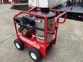 A red and stainless steel Magnum 4000 hot water pressure washer with wheels and hoses attached