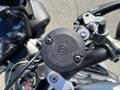 Close-up of the fuel cap on a 2018 Triumph Street Triple RS motorcycle showing a circular design and warning labels