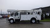 A 2005 International 4300 bucket truck with a white exterior and an elevated hydraulic lift arm positioned on the truck's chassis