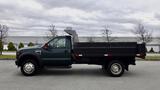 A green 2008 Ford F-450 SD truck with a flatbed, side profile view, featuring large tires and dual rear wheels