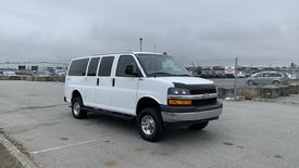 A 2017 Chevrolet Express Quigley 4x4 van with a white exterior and silver wheels parked in a lot