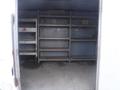 Empty interior of a 2010 Forest River Enclosed trailer featuring several metal shelves along the walls with wooden surfaces