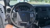 Interior view of a 2011 Ford F-450 SD showing the steering wheel dashboard and control panel