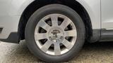 A close-up of a silver wheel from a 2013 Lincoln MKT showing five spokes and a central hubcap with the Lincoln logo