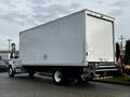 A 2022 Ford F-750 truck with a large white box cargo area and a flatbed rear section