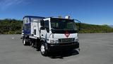 A white 2006 Ford LCF 550 truck equipped with safety signage and a blue covered cargo area