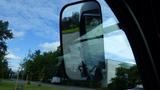 2018 Kubota RTV X1100c with a side mirror reflecting the surroundings and a view of the ground and road