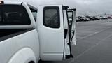 A 2016 Nissan Frontier with an open rear door showing the interior of the truck cab