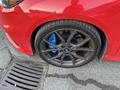 A red 2018 Ford Focus with dark alloy wheels featuring blue brake calipers close up of the tire and wheel well