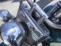 A close-up of a 2009 Harley-Davidson FLSTC showing its chrome handlebars and headlight assembly with a polished metal finish