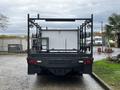 A 2005 Freightliner M2 106 truck with a flatbed design featuring lights and a minimalist rear structure