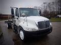 A white 2006 International 4300 truck with a large front grille and side mirrors parked at an angle