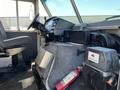 Interior view of a 2011 Ford Econoline showing the driver's seat dashboard and equipment including a fire extinguisher and control panel