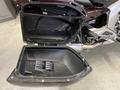 A 2013 BMW K1600GTL motorcycle side storage compartment with the lid open displaying a spacious interior and warning label inside