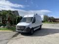 A 2021 Mercedes-Benz Sprinter van with a white exterior and gray front bumper parked on a paved area