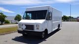 A 2011 Ford Econoline van with a white exterior and a flat front design parked on a street