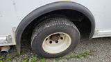 A close-up view of a dirty tire on a 2006 Ford Econoline showing the wheel rim and tread pattern