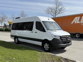 A 2023 Mercedes-Benz Sprinter van with a white body and gray accents parked on a lot