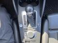 A close-up view of the gear shift console in a 2016 Audi A3 featuring a leather-wrapped gear knob and control buttons for navigation and radio