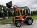 A 2001 Agco ST40 tractor with a front loader bucket and large rear tires parked with an operational design featuring an orange body and black seating