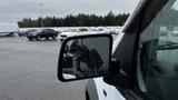 A close-up view of the side mirror of a 2012 Ford Transit with raindrops on the glass