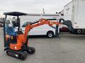 A compact 2024 AGT L12R excavator with an orange body and a black bucket attachment parked to the side with its arm positioned forward