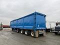 A blue 2011 Freightliner Cascadia Nordic truck trailer with a long, flatbed design and multiple wheels attached at the rear