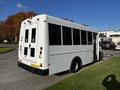2015 Chevrolet Express bus with a white exterior and large windows parked on a lot