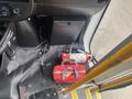 Interior view of a 2018 Chevrolet Express showing a red emergency kit on the floor next to a fire extinguisher and some loose wires near the driver's seat