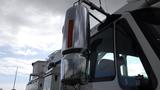 A chrome exhaust stack is mounted on a 2008 International 7500 truck with a large side mirror and visible cab window