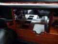 Interior detail of a 2008 Cadillac Limousine featuring a wooden console with multiple cup holders and a sleek design