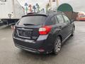 A 2014 Subaru Impreza hatchback in dark gray with a clean design showcasing its rear and side profile