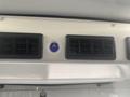 Air conditioning control panel featuring vents and a blue emblem in a 2017 Chevrolet Express