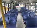 Interior view of a 2017 Chevrolet Express showing rows of blue seats with armrests and an empty aisle in the center